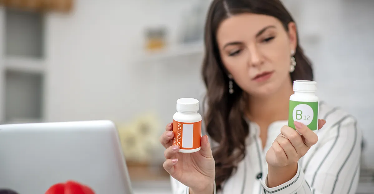 Woman checking supplement bottles, vitamin B12