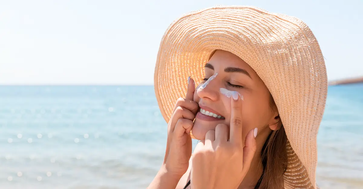 Understanding sunscreen ingredients, woman applying sunscreen on a beach
